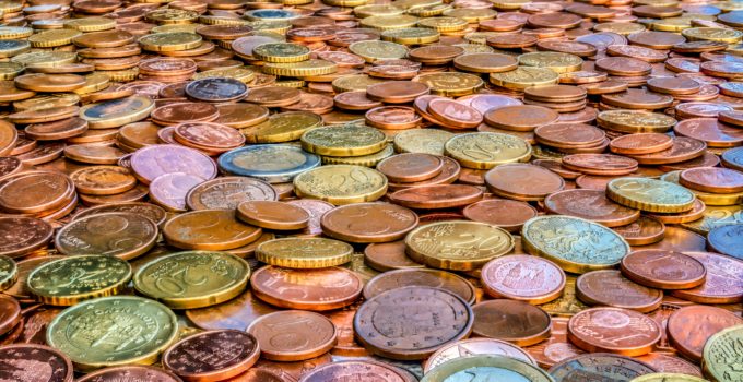 Closeup of many coins of various values and colors. Concept of wealth and abundance.